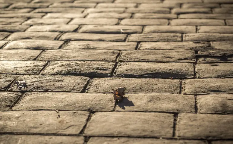 Calle peatonal pavimentada con hormigón impreso efecto adoquín envejecido en Moguer, Huelva