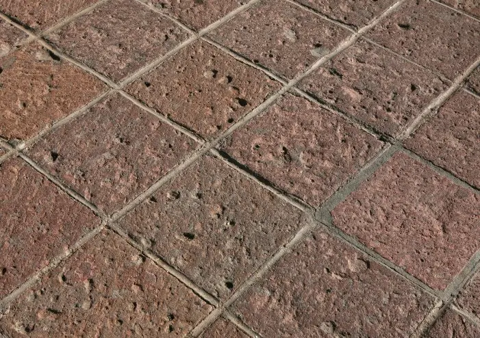Rampa de acceso a garaje pavimentada con hormigón impreso molde adoquín en color terracota en Huelva